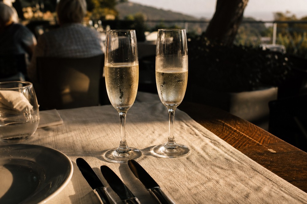 Champagne flutes on a linen tablecloth aboard a dinner boat, no text, no logos, no people