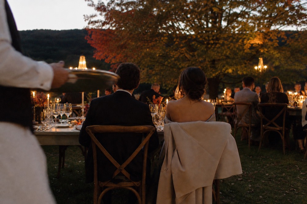 An elegantly dressed couple at a formal dinner table with candlelight on a Seine cruise, no text, no logos, no people.