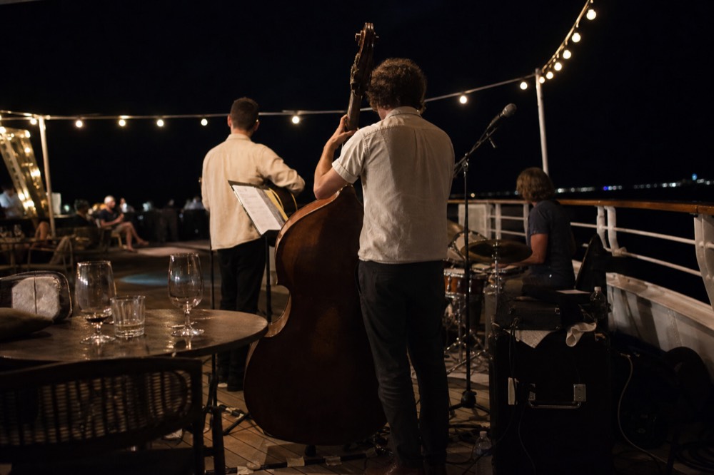 Live musicians performing on a dinner cruise deck on the Seine, no text, no logos, no people