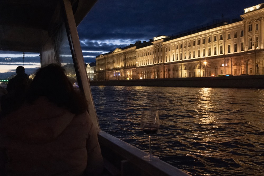 Lit-up Parisian monuments seen from the water at night from a cruise deck, no text, no logos, no people