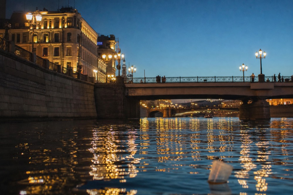 Paris skyline and lit bridges seen from the water at night, no text, no logos, no people