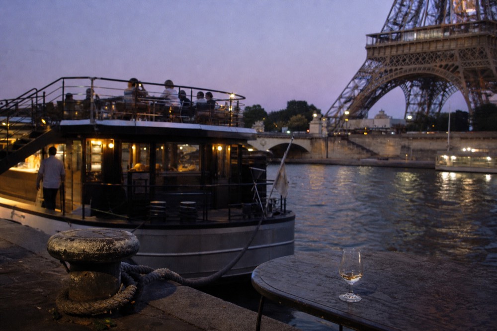Passenger dinner boat moored on the Seine near the Eiffel Tower at twilight, no text, no logos, no people