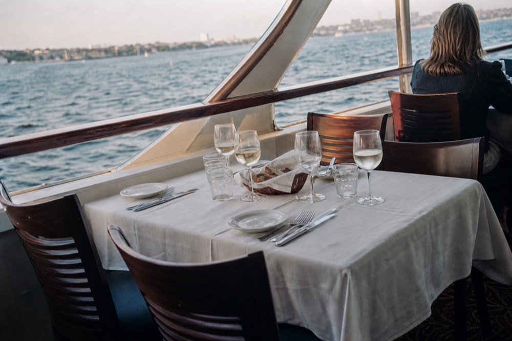 Set dinner table with wine glasses aboard a Seine cruise boat, no text, no logos, no people