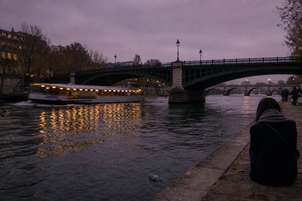Seine river at dusk with boat lights reflecting, no text, no logos, no people