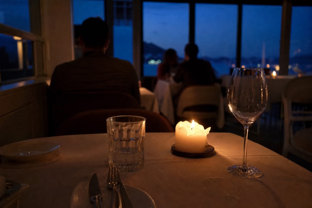 An elegant dinner cruise table setting with candles and glassware, no text, no logos, no people