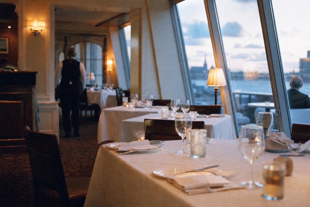 A smart-casual dinner cruise dining room set for an evening service, no text, no logos, no people