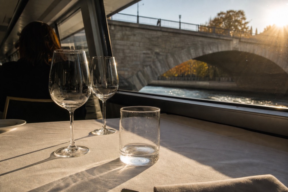 An elegant fine-dining place setting with multiple glasses on a quiet modern boat, no text, no logos, no people.